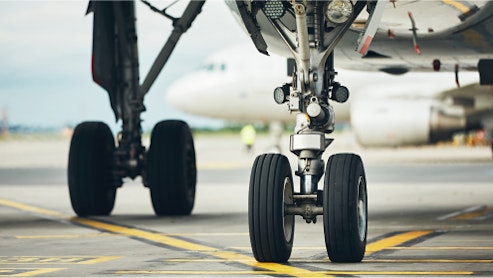 Image of the wheels of a plane on tarmac.