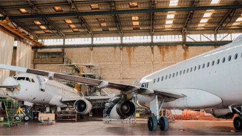 Image of airplanes in a hanger, awaiting maintenance.