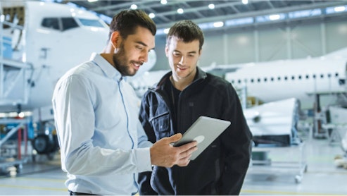 Image of two aviation professionals, consulting with each other.